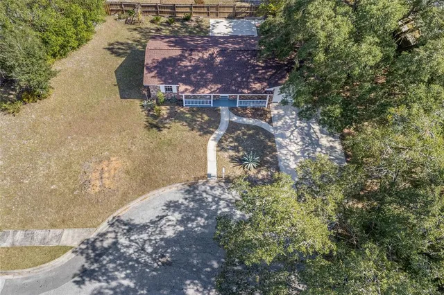 a aerial view of a house with a yard and large trees