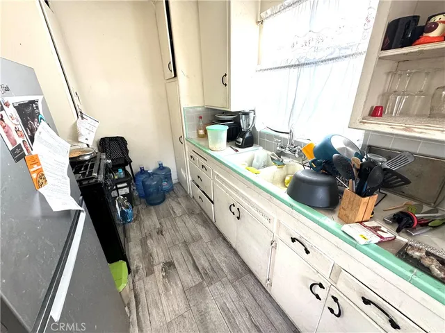 a kitchen with sink a window and cabinets