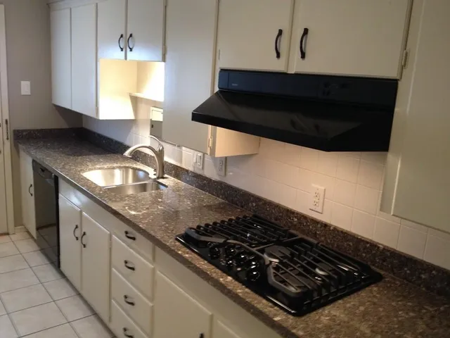 a kitchen with granite countertop a stove and a sink