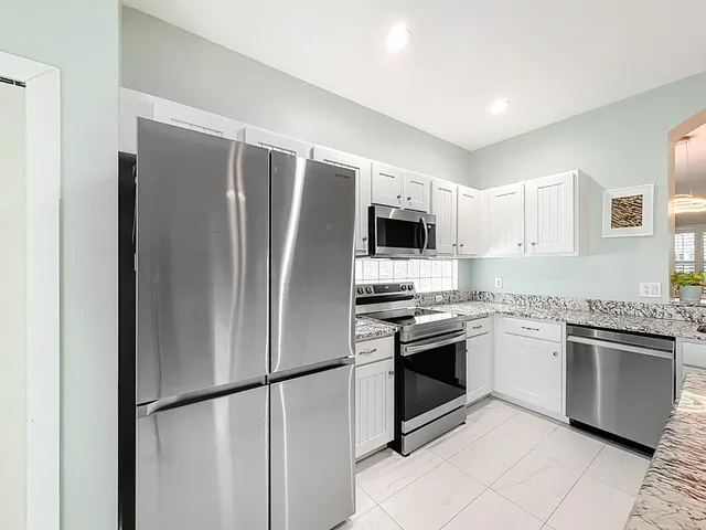 an empty room with wooden floor closet and windows