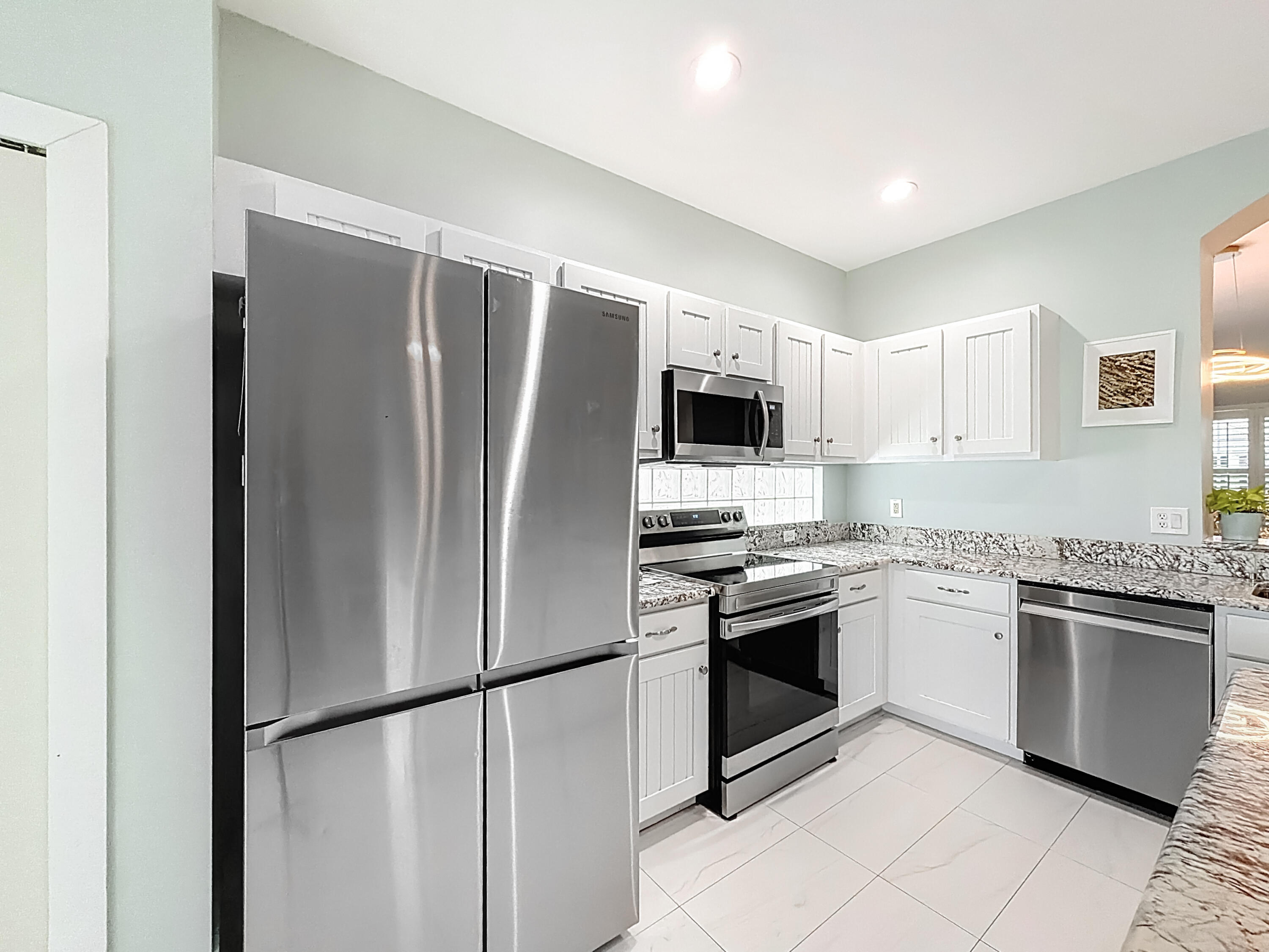 1143 Canoe Point Delray Beach, FL 33444 - Photo 30 of 85 a kitchen with stainless steel appliances granite countertop a refrigerator a stove a sink and a microwave