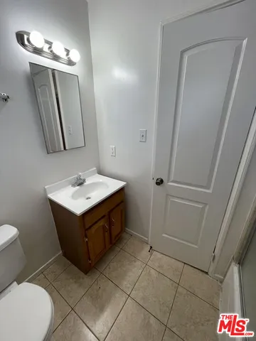 a bathroom with a sink mirror vanity and toilet