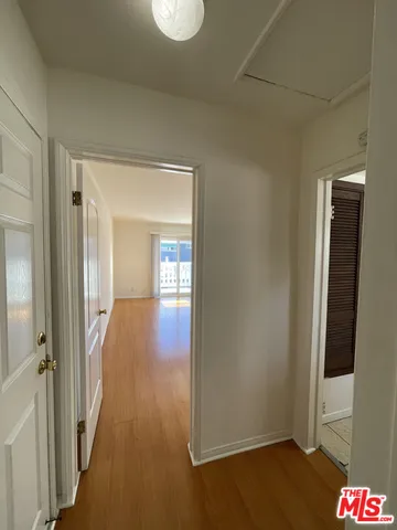 a view of a hallway with wooden floor and closet