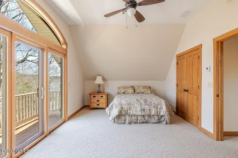 a bedroom with a bed and a large window with view of closet