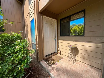 a view of a porch with a table and chairs and potted plants