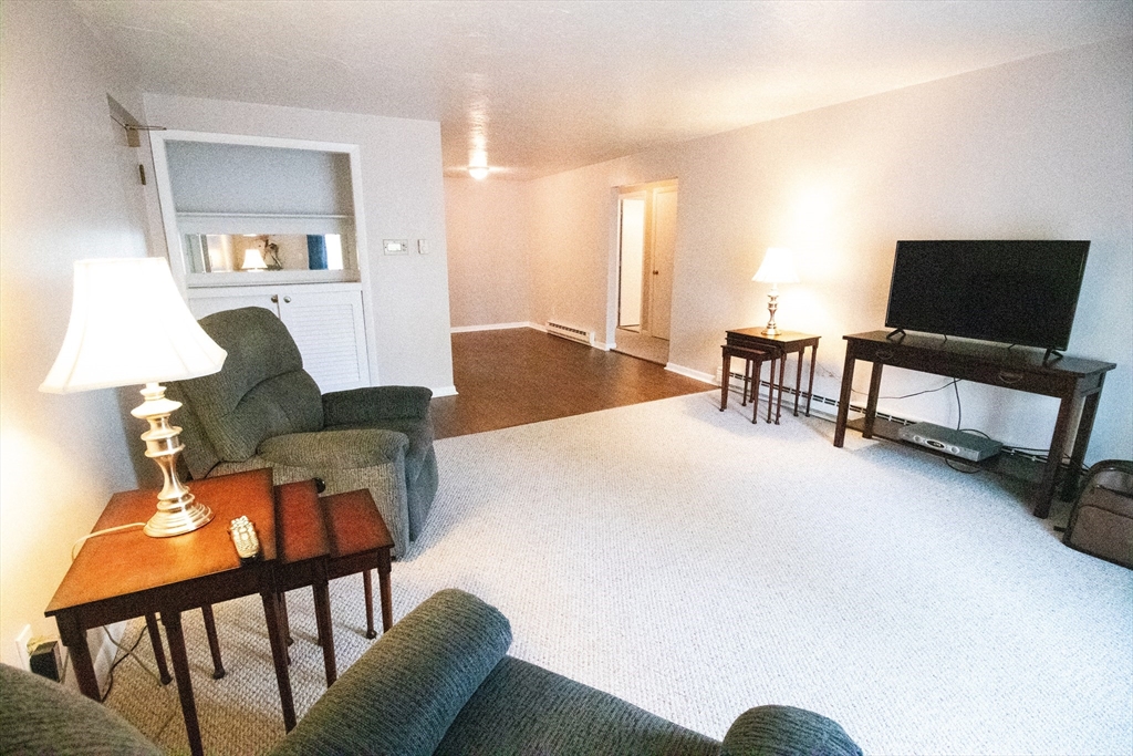 57 Will Drive, Unit 168 Canton, MA 02021 - Photo 2 of 15 a living room with furniture and a flat screen tv
