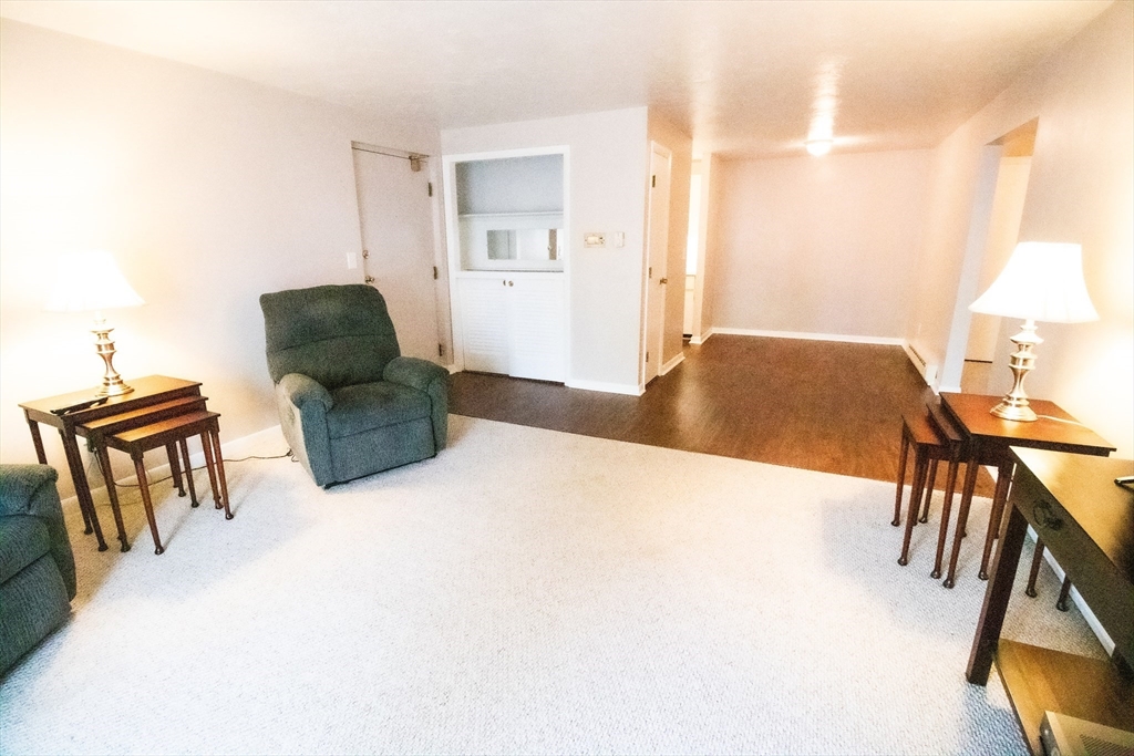 57 Will Drive, Unit 168 Canton, MA 02021 - Photo 4 of 15 a living room with furniture and a dining table with bookshelf