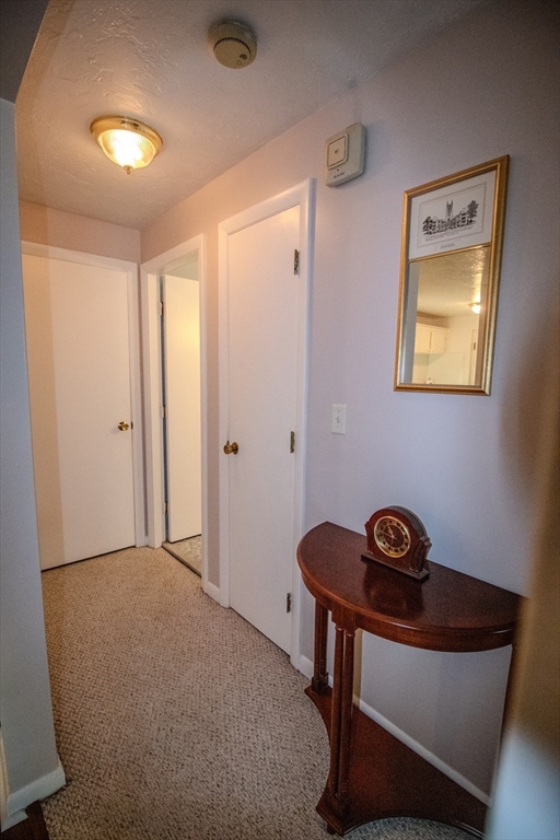 57 Will Drive, Unit 168 Canton, MA 02021 - Photo 8 of 15 a view of a hallway to a room with wooden floor and windows