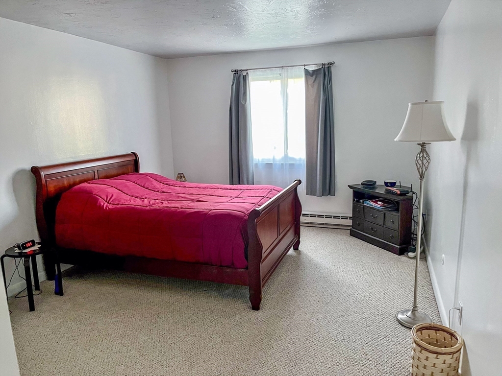 57 Will Drive, Unit 168 Canton, MA 02021 - Photo 9 of 15 a bedroom with a bed and cabinets