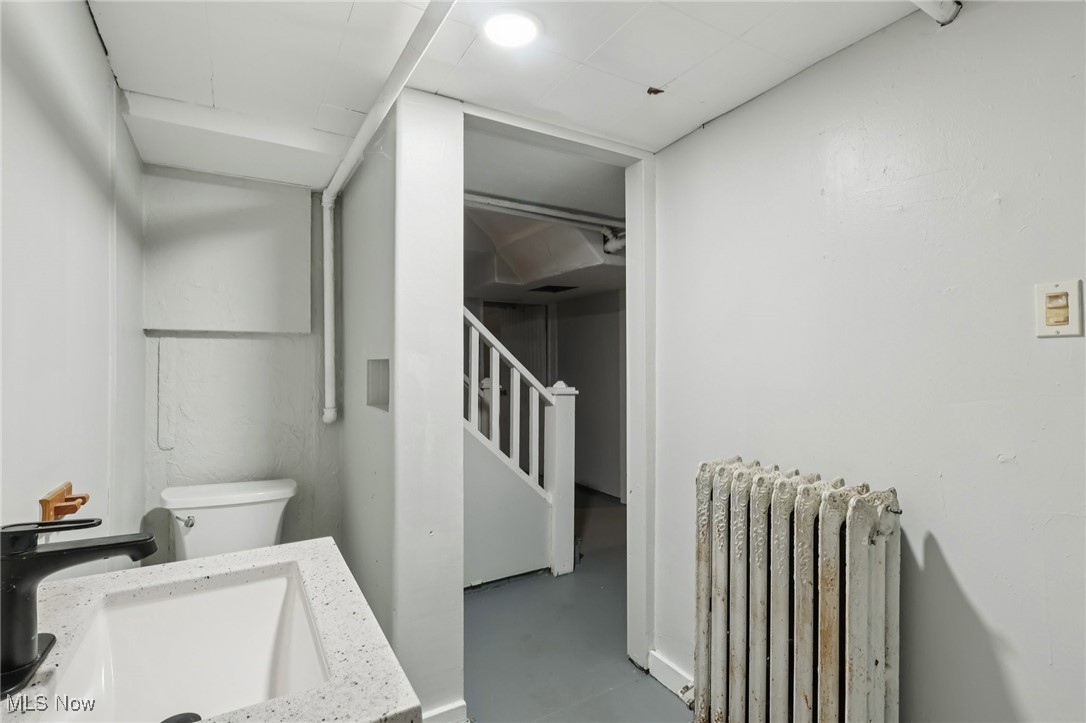 748 Chalker Street Akron, OH 44310 - Photo 21 of 48 Half bath with radiator and finished concrete flooring