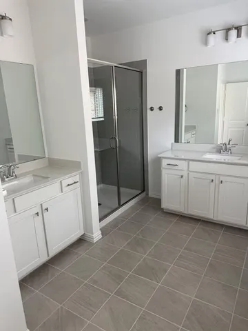 a spacious bathroom with a granite countertop sink a mirror and a bathtub