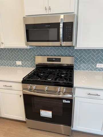 a stove top oven sitting inside of a kitchen