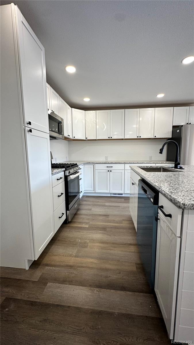 215 6th Street Hugo, CO 80821 - Photo 12 of 28 a kitchen with stainless steel appliances granite countertop a sink stove and refrigerator