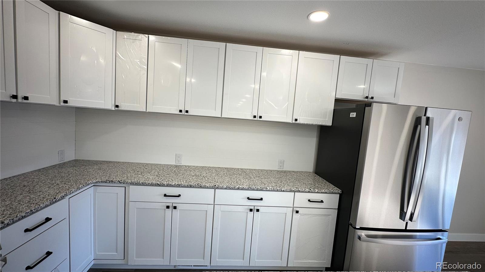 215 6th Street Hugo, CO 80821 - Photo 13 of 28 a kitchen with white cabinets and refrigerator