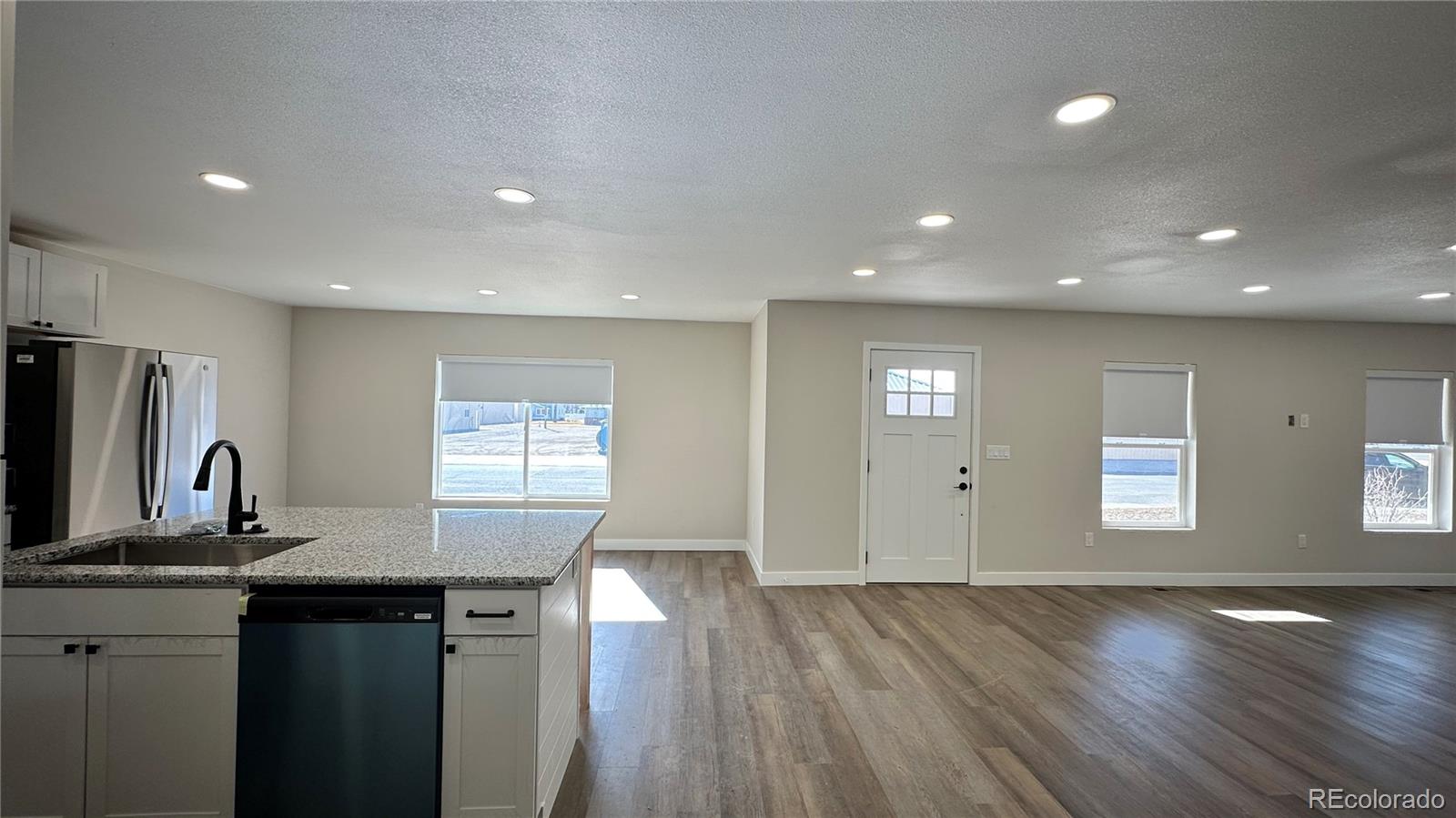215 6th Street Hugo, CO 80821 - Photo 14 of 28 a kitchen with granite countertop a sink and wooden floor