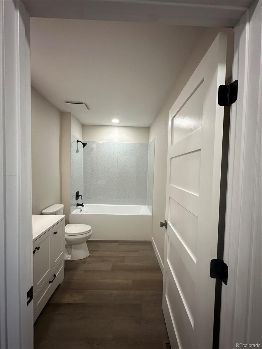 215 6th Street Hugo, CO 80821 - Photo 17 of 28 a bathroom with a double vanity sink toilet a shower and a bathtub