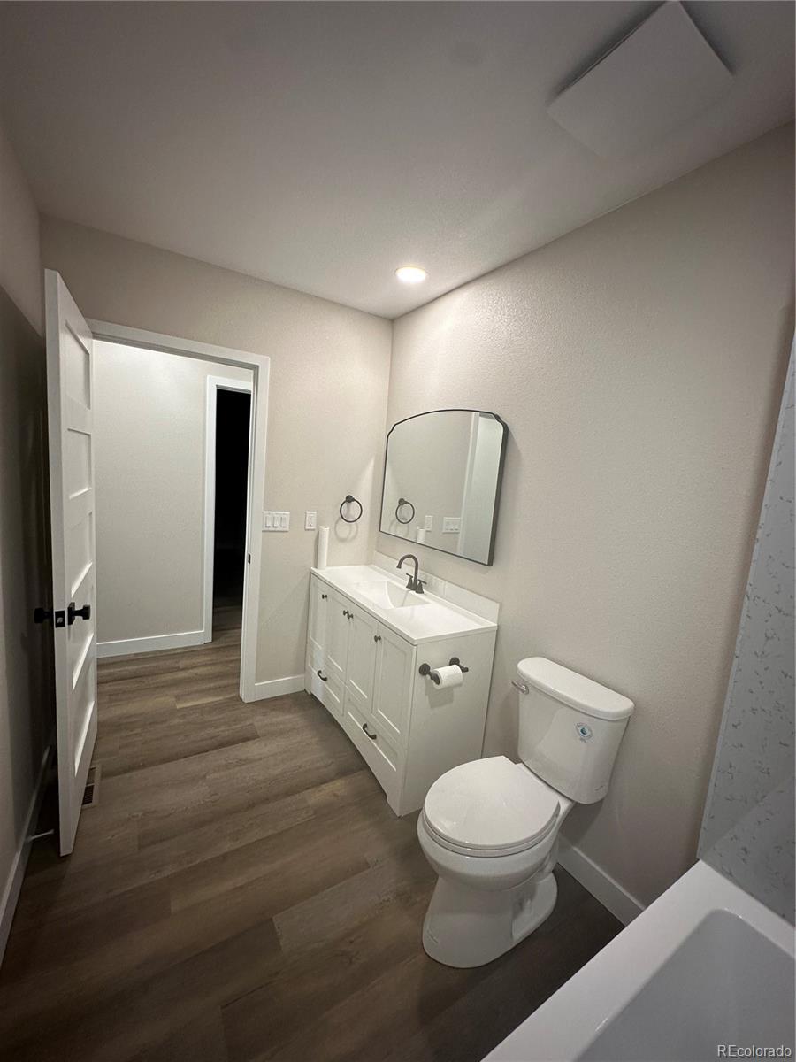215 6th Street Hugo, CO 80821 - Photo 18 of 28 a bathroom with a toilet a sink and mirror