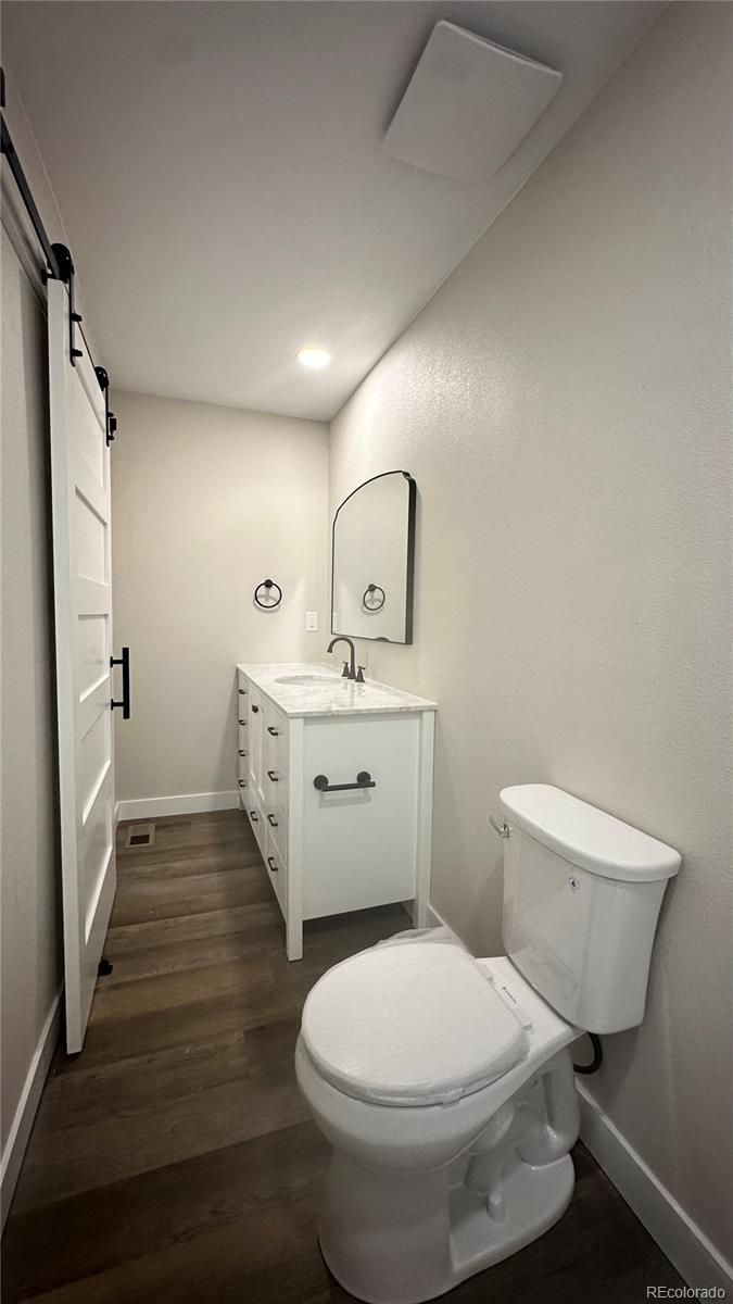 215 6th Street Hugo, CO 80821 - Photo 22 of 28 a bathroom with a toilet sink and mirror