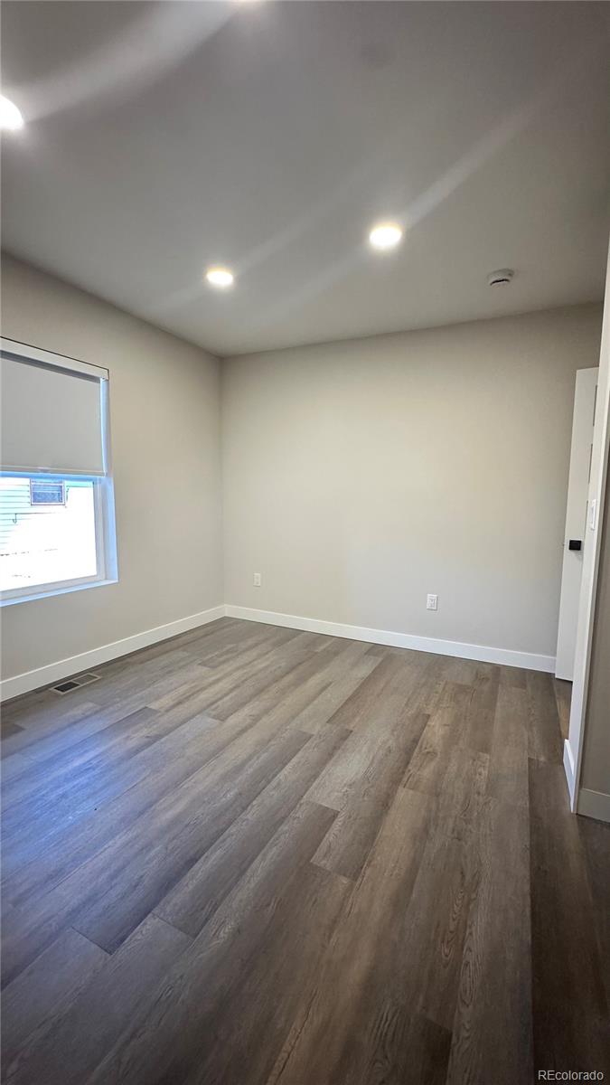 215 6th Street Hugo, CO 80821 - Photo 23 of 28 an empty room with wooden floor and windows