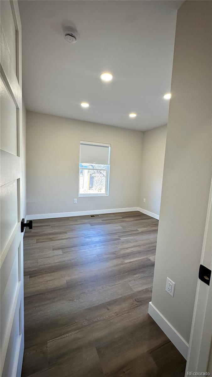 215 6th Street Hugo, CO 80821 - Photo 25 of 28 an empty room with wooden floor and windows