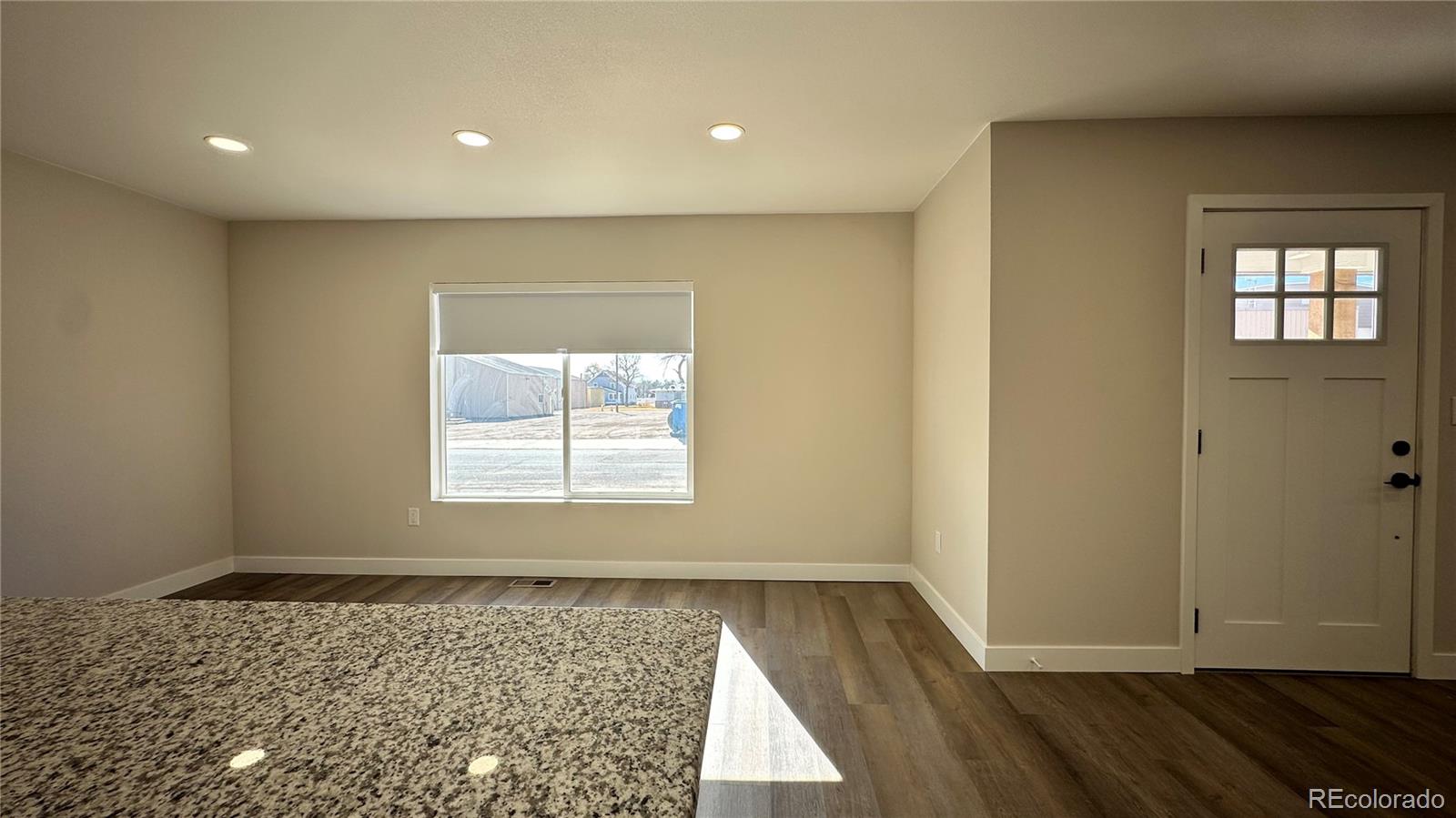 215 6th Street Hugo, CO 80821 - Photo 8 of 28 a view of an empty room with wooden floor and a window