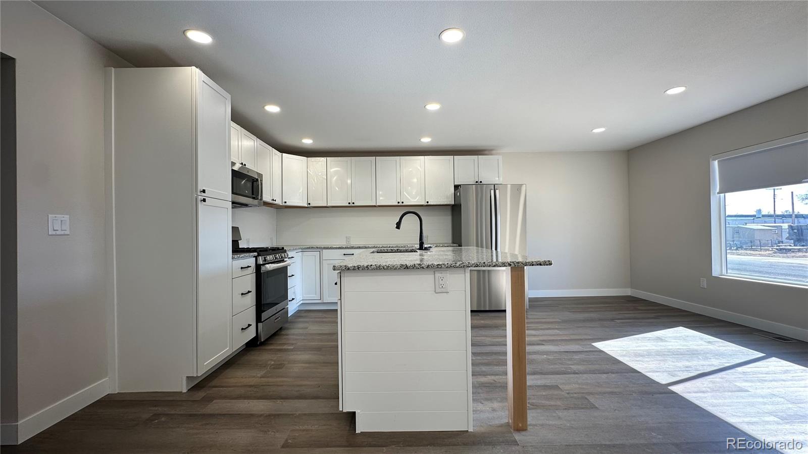 215 6th Street Hugo, CO 80821 - Photo 10 of 28 a kitchen with stainless steel appliances granite countertop a sink a stove and a refrigerator