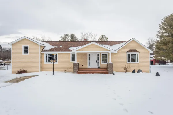 a view of a house with a yard and fence