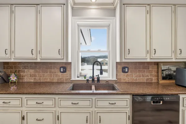 a kitchen with white cabinets and sink
