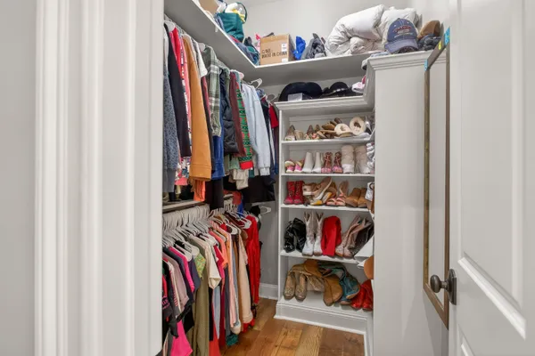 a view of walk in closet with clothes and shoes