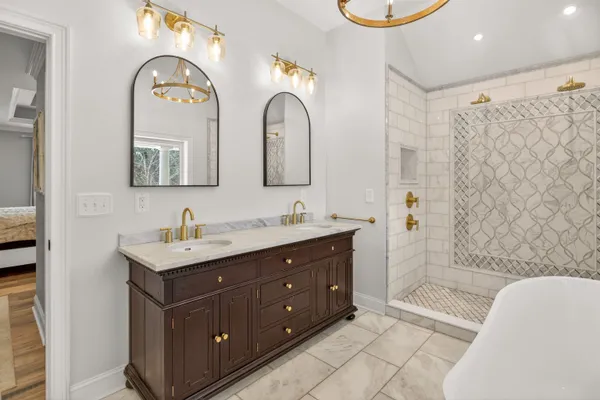 a spacious bathroom with a double vanity sink mirror and bathtub