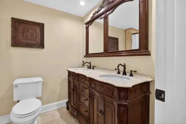 a bathroom with a toilet a sink and mirror