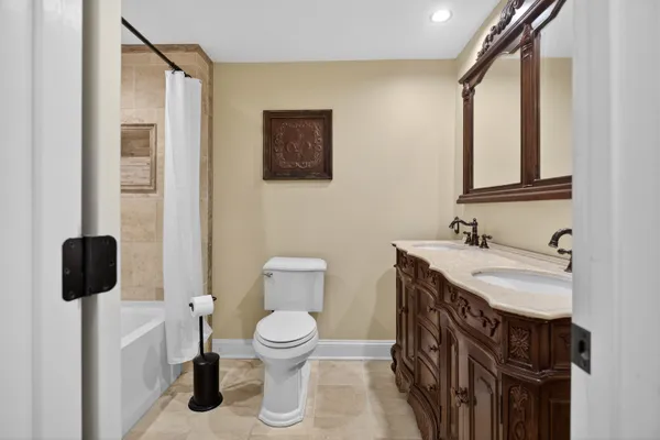 a bathroom with a granite countertop sink toilet and mirror