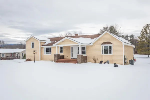 a view of a house with a yard covered in snow