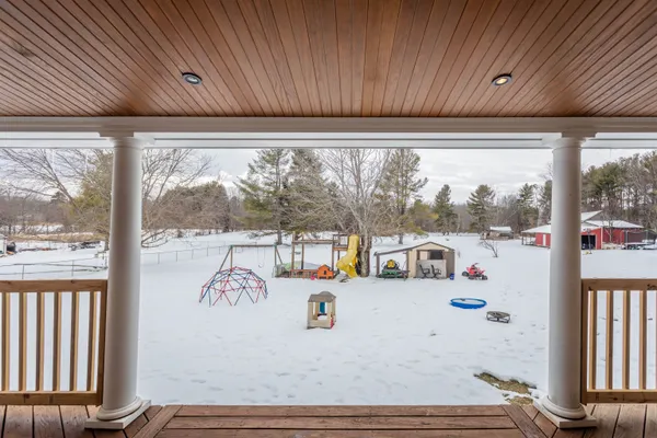 a view of a house with a cars park covered with tall trees