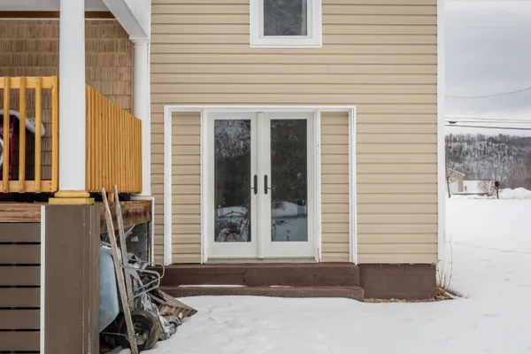 a view of a house with a yard covered in snow