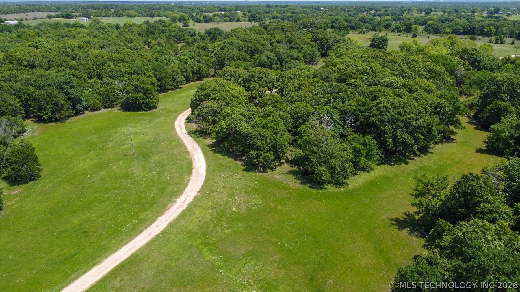 13248 North 3540th Road Maud, OK 74854 - Photo 24 of 98 Expansive land parcel featuring a winding gravel drive and abundant mature tree cover