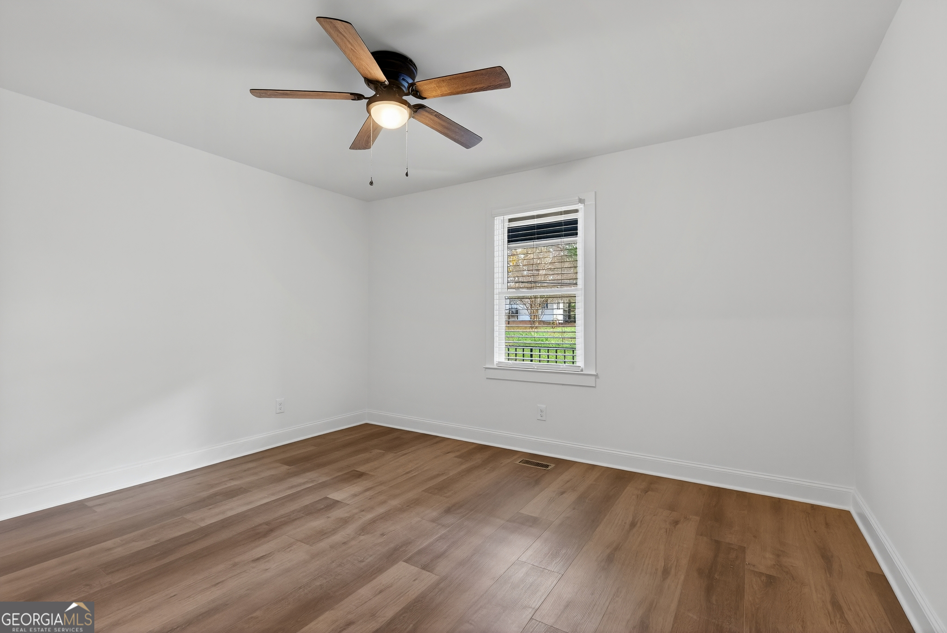 475 Vine Street, Unit B Madison, GA 30650 - Photo 12 of 23 an empty room with a window and ceiling fan