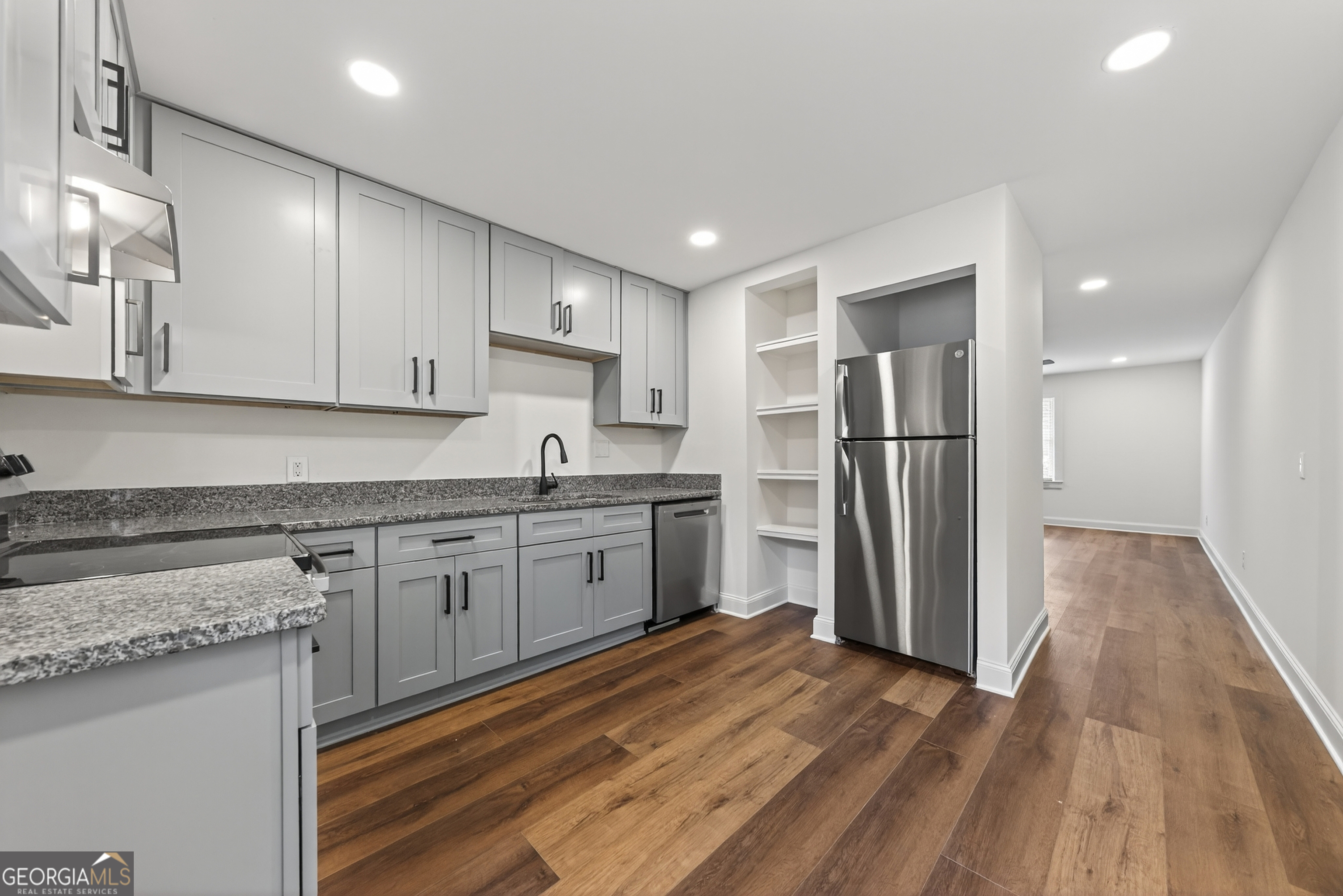 475 Vine Street, Unit B Madison, GA 30650 - Photo 9 of 23 a kitchen with granite countertop a refrigerator and a sink