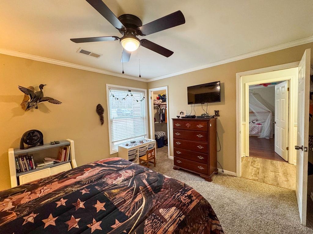127 Walton Loop Covington, TN 38019 - Photo 31 of 40 a bedroom with a bed and a chandelier