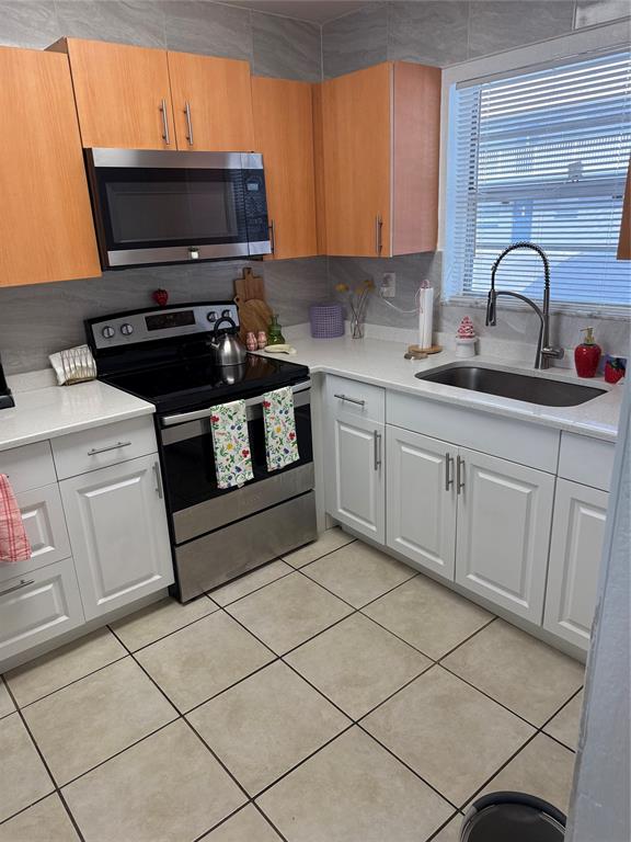 4745 Northwest 9th Drive, Unit 4745 Fort Lauderdale, FL 33317 - Photo 2 of 15 a kitchen with a stove a sink and a microwave