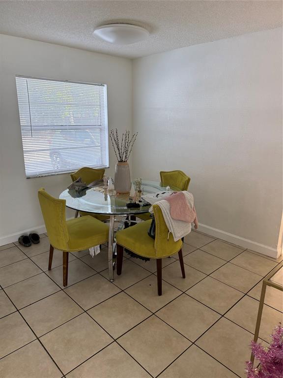 4745 Northwest 9th Drive, Unit 4745 Fort Lauderdale, FL 33317 - Photo 4 of 15 a blue chair sitting in a room next to a window