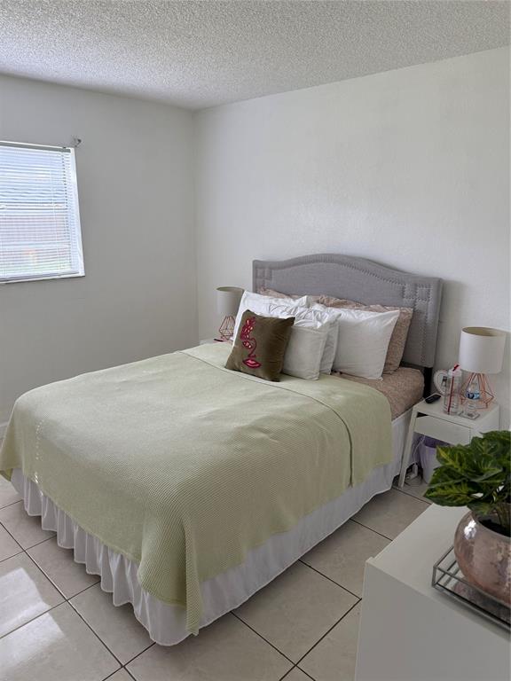 4745 Northwest 9th Drive, Unit 4745 Fort Lauderdale, FL 33317 - Photo 5 of 15 a bedroom with a bed and a potted plant