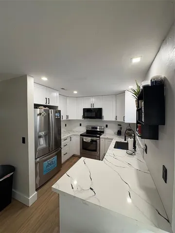 a kitchen with stainless steel appliances a refrigerator and a stove top oven