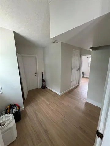 a view of empty room with wooden floor
