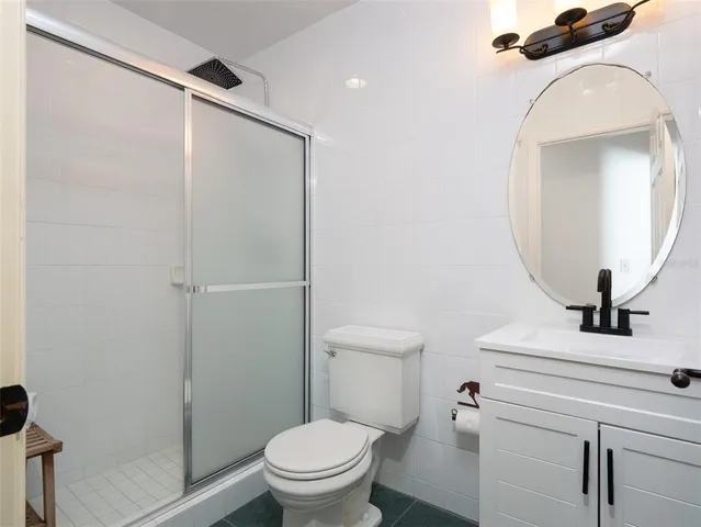 a bathroom with a toilet sink vanity and mirror