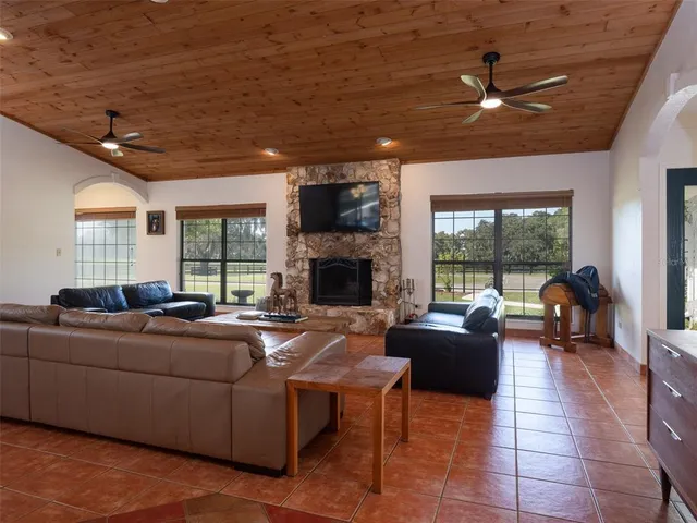 a living room with fireplace furniture and a large window