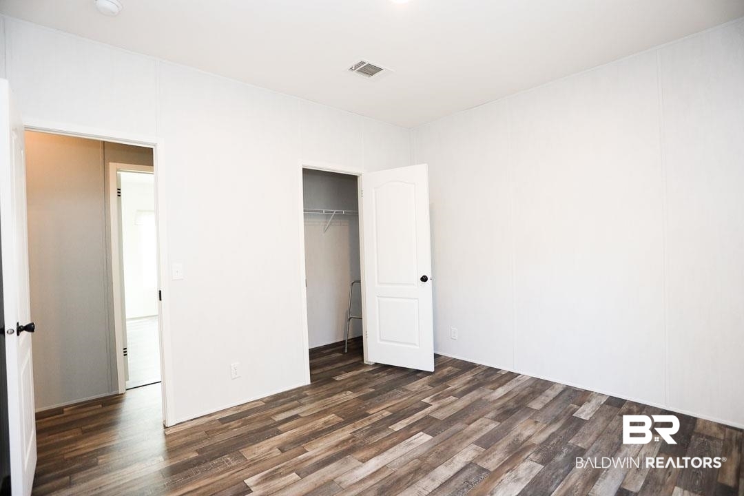 19180 Horseshoe Circle Seminole, AL 36574 - Photo 23 of 38 Unfurnished bedroom featuring dark wood-style flooring and a closet