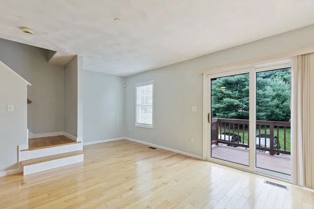 a view of an empty room with glass door and a window