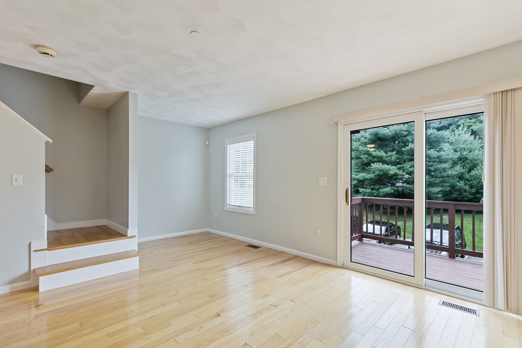 555 Main Street, Unit 10 Woburn, MA 01801 - Photo 12 of 39 a view of an empty room with wooden floor and a window