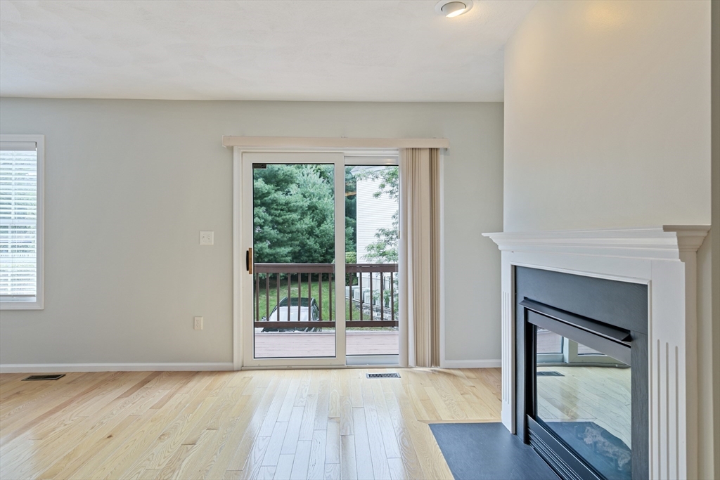 555 Main Street, Unit 10 Woburn, MA 01801 - Photo 13 of 39 a view of an empty room with wooden floor and a window
